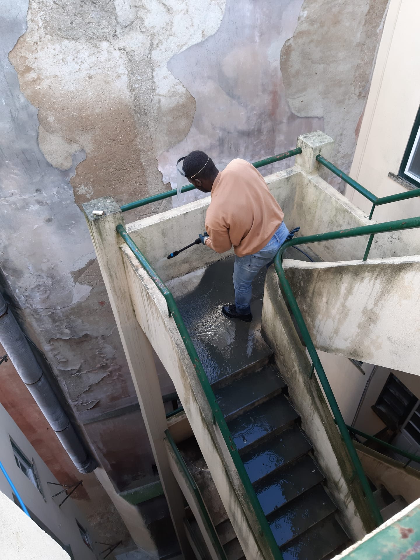 Escadas de pedra sujas de terra a serem lavadas por um profissional de limpeza com equipamento a pressão